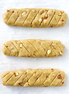 three cookies are lined up on a white surface