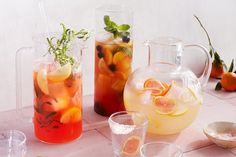 various pitchers and glasses filled with drinks on a table