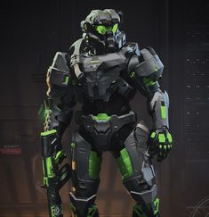 a futuristic suit with green accents stands in front of a dark background and looks like he's ready for battle