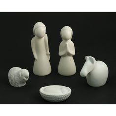 three white ceramic figurines and a bowl