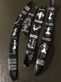 three wooden spoons with painted designs on them