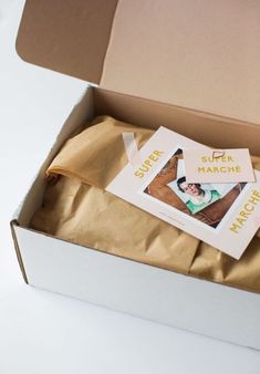 an open box with some pictures on it and a brown bag in the bottom right corner