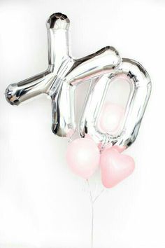 the balloon is shaped like a dog and has pink heart balloons attached to its tail