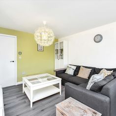 a living room filled with furniture and a flat screen tv on top of a hard wood floor