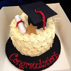 a graduation cake in a box with congratulations written on the side and a mortar cap