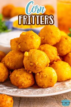 fried corn fritters on a white plate with orange juice and parsley in the background