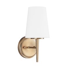 a wall light with a white shade on the side and a gold finish to it