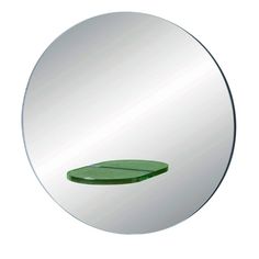 a round mirror with a green leaf on it