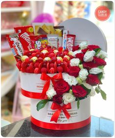 a valentine's day gift basket with roses, candy and candies in it