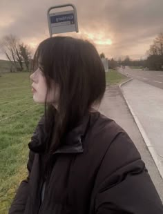 a woman standing in front of a street sign