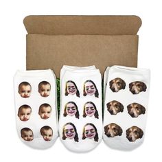 three pairs of socks with pictures of people and dogs on them in front of a cardboard box