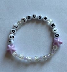 a bead bracelet with words and stars on it that spell out real tough kids