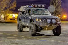 an off road vehicle parked in a parking lot with lights on it's headlamps