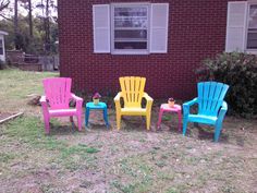 four plastic chairs sitting in front of a brick house