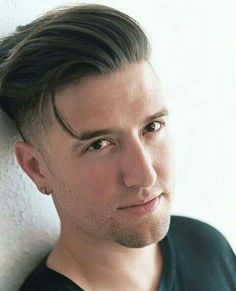 a close up of a person wearing a black shirt with a haircut on his head