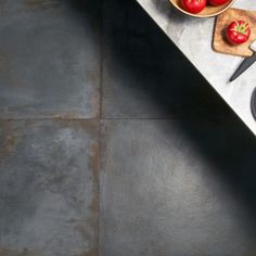 a kitchen counter with bowls of tomatoes and a cutting board on the counter next to it