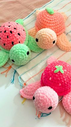 three crocheted stuffed animals sitting on top of a bed next to each other