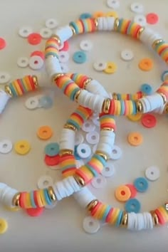 two bracelets made out of plastic beads on a white surface with colorful circles around them