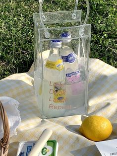 a bottle of lemonade sitting on top of a table next to an orange and some other items