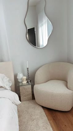 a bedroom with a chair and mirror on the wall