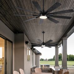 the ceiling fan is hanging from the roof above the table and chairs on the porch