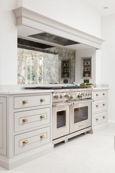 a kitchen with an oven, stove and counter tops in the middle of the room