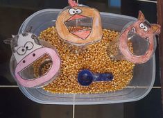 three plastic containers filled with food on top of a tiled floor next to a wall