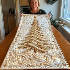 a woman holding up a quilted christmas tree