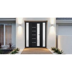 a black and white door in front of a house with two plants on the side