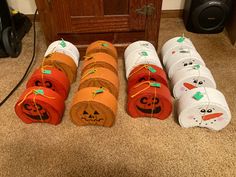 several rolls of toilet paper with faces on them sitting in front of a wooden door