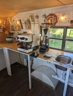 a coffee maker sitting on top of a kitchen counter next to a sink and window