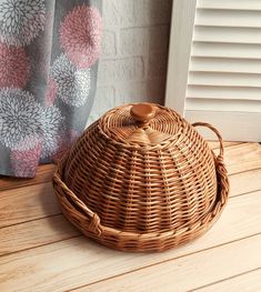 a wicker basket sitting on top of a wooden floor next to a window sill