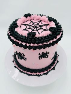 a pink and black decorated cake sitting on top of a white plate