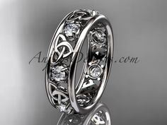 an intricately designed wedding ring with diamonds on the side and celtic design in the middle