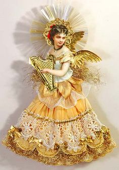 an angel figurine holding a harp on a white background with gold trimmings