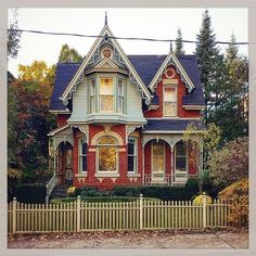 an old victorian style house with a picket fence