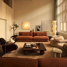 a living room filled with furniture and a large window in the center wall behind it