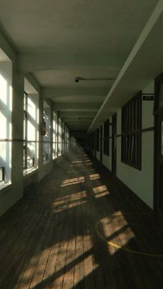 the sun shines through windows in an empty hallway