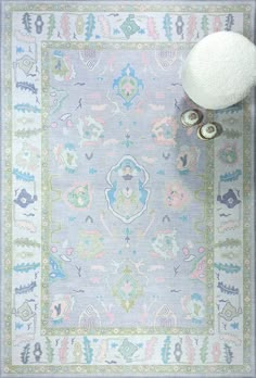 a blue rug with an ornate design on the bottom and a white pom - pom