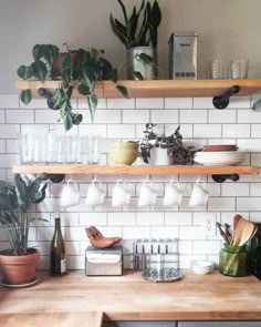 a shelf filled with pots and pans sitting on top of a tiled kitchen wall