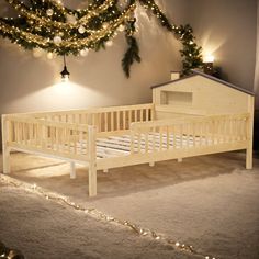 a small wooden bed sitting on top of a carpeted floor next to a christmas tree