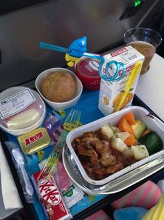 an airplane tray with some food and drinks on it, along with other items to eat