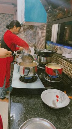 two women are preparing food on the stove