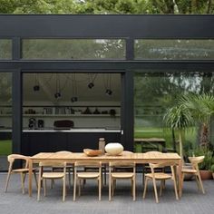 an outdoor dining area with wooden chairs and table