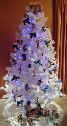 a white christmas tree with blue lights and ornaments