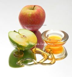 an apple sitting on top of a table next to a bowl of oil and a pair of handcuffs