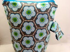 a blue and brown flowered purse on a white table