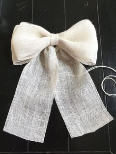 a white bow tied on top of a wooden floor