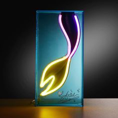 a blue glass vase with a yellow and purple light in the shape of a leaf