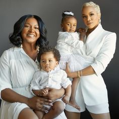 two women and a baby are posing for a family photo with one holding the child